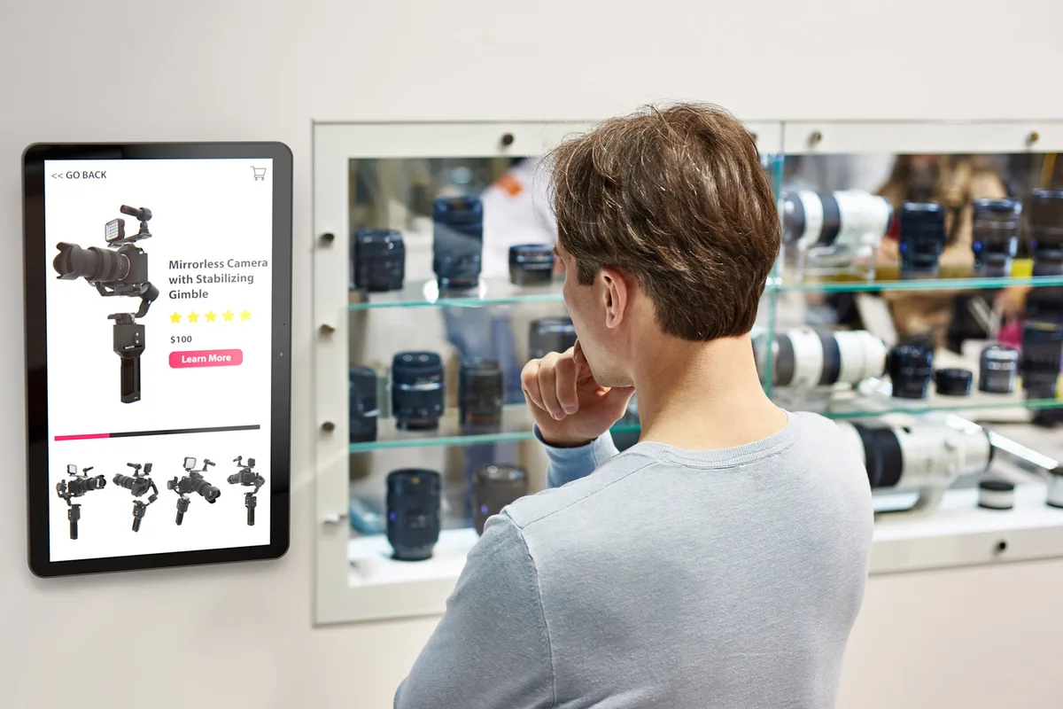 Persona consultando información de productos en un kiosko Zebra dentro de una tienda